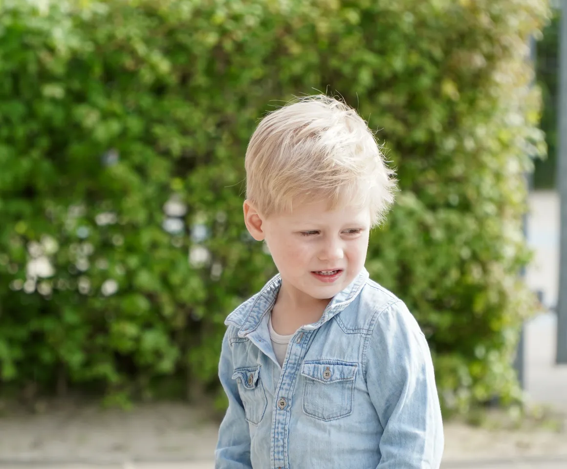 Kind staat buiten bij de heg bij gastouder van kinderopvang Kind&co ludens