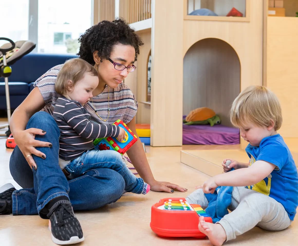 Kinderen spelen samen onder begeleiding van een pedagogisch medewerker bij kinderopvang Kind&co ludens