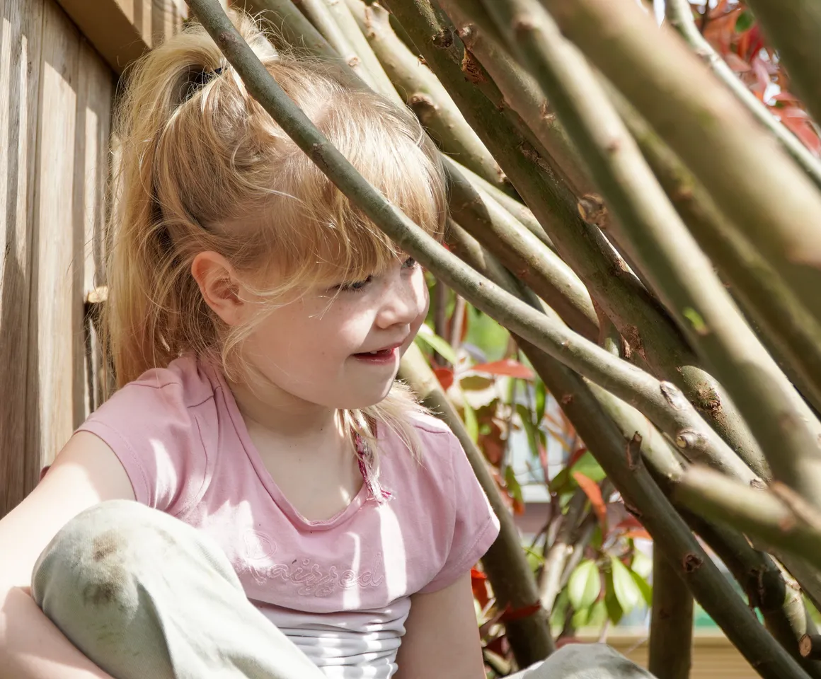 Kind speelt buiten in Wilgentakken huisje bij gastouder van kinderopvang Kind&co ludens
