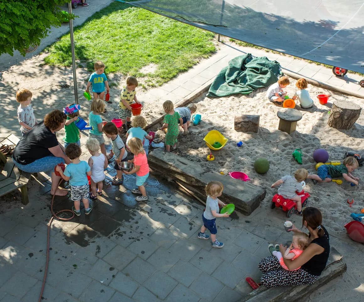 Kinderen spelen samen met water en in de zandbak bij kinderdagverblijf Jodokus, kinderopvang Kind&co ludens