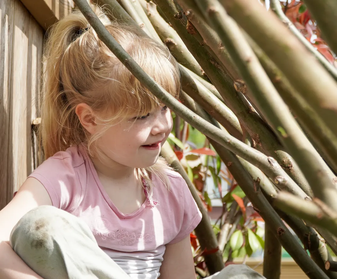 Kind speelt buiten in Wilgentakken huisje bij gastouder van kinderopvang Kind&co ludens