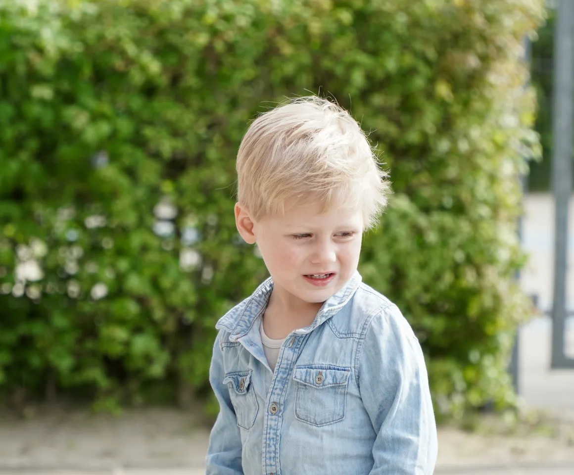 Kind staat buiten bij de heg bij gastouder van kinderopvang Kind&co ludens