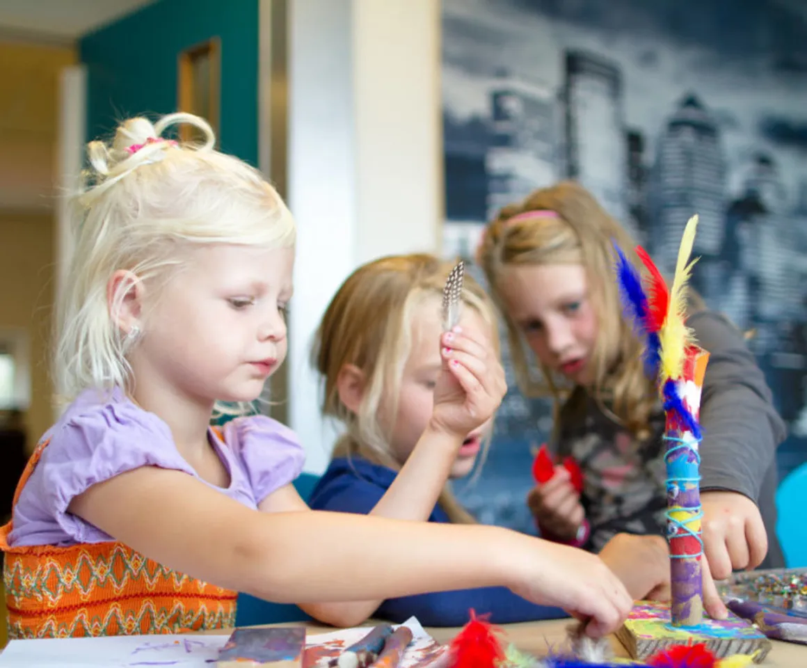 Kinderen knutselen met veertjes bij buitenschoolse opvang Touwladder, kinderopvang Kind&co Ludens