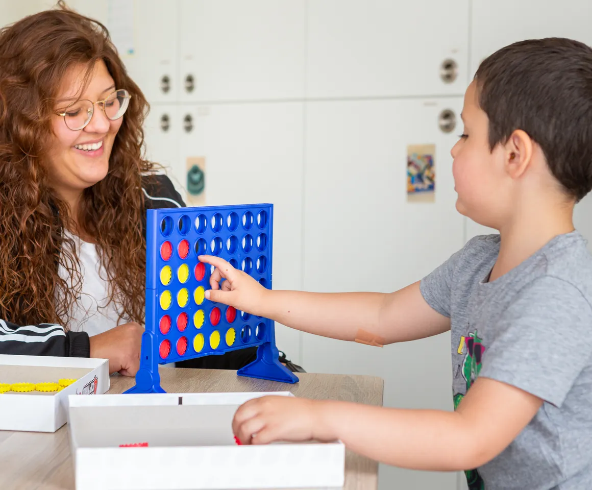 Kind speelt samen met een pedagogisch medewerker een spel bij kinderopvang Kind&co ludens