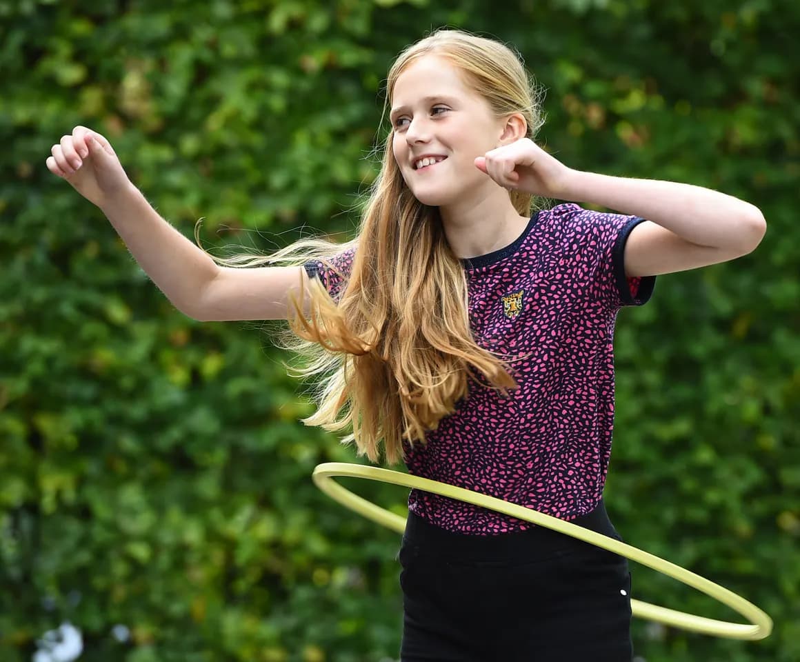Kind van de BSO hoepelt buiten bij kinderopvang Kind&co ludens