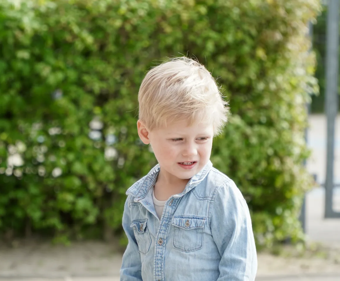 Kind staat buiten bij de heg bij gastouder van kinderopvang Kind&co ludens