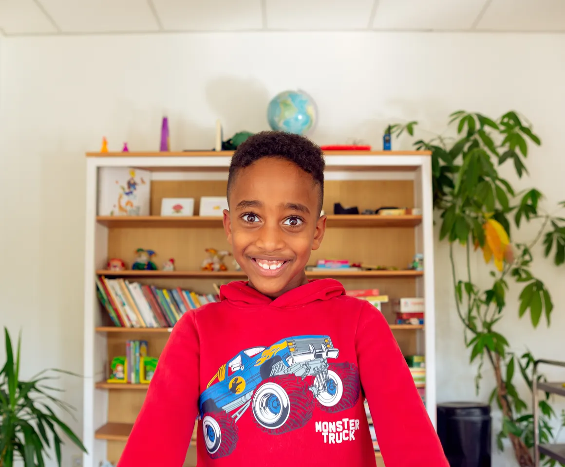 Kind bij de BSO lacht heel blij en straalt bij kinderopvang Kind&co ludens