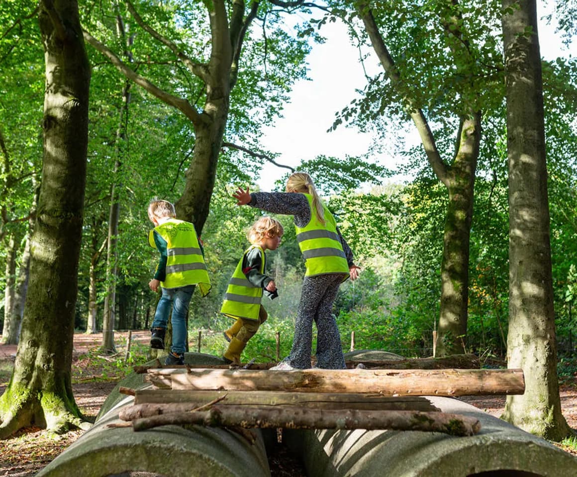 Kinderen buiten in het bos aan het spelen bij BSO Scouts Baarn van kinderopvang Kind&co ludens
