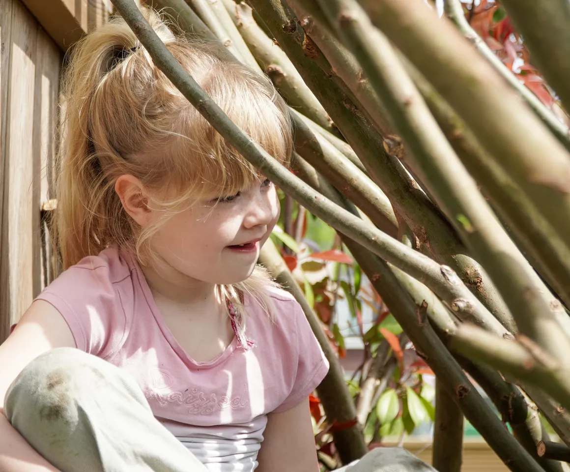 Kind speelt buiten in Wilgentakken huisje bij gastouder van kinderopvang Kind&co ludens