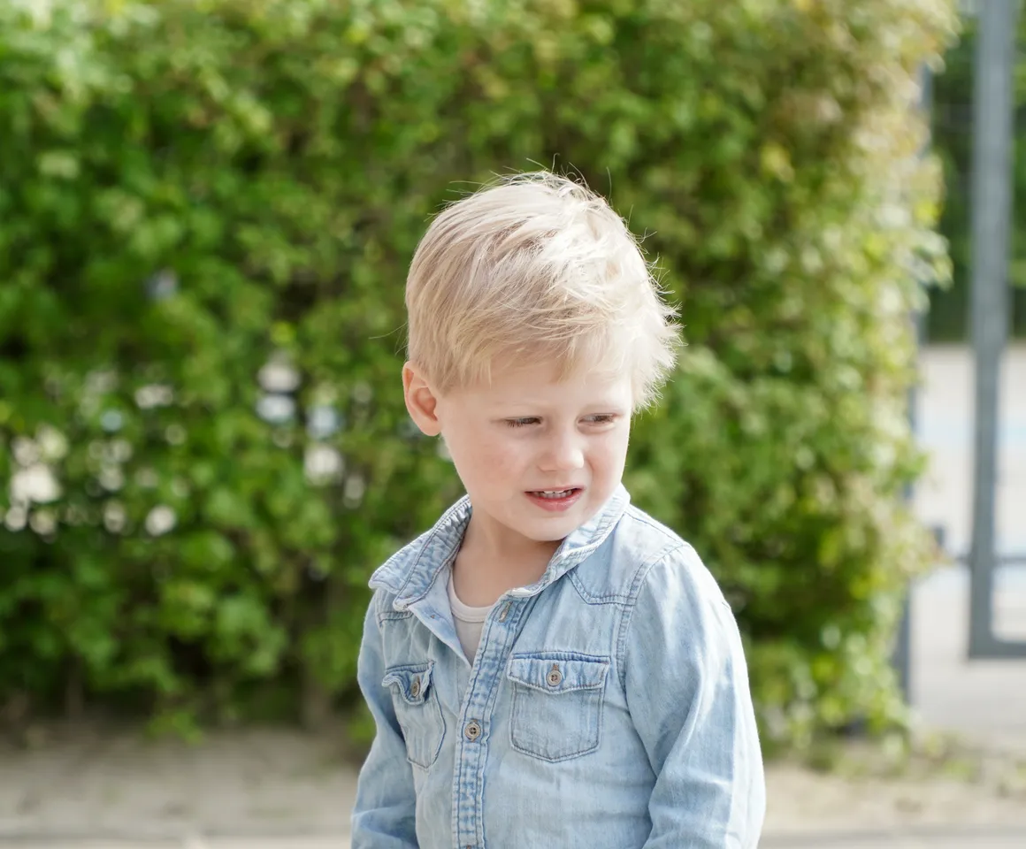 Kind staat buiten bij de heg bij gastouder van kinderopvang Kind&co ludens