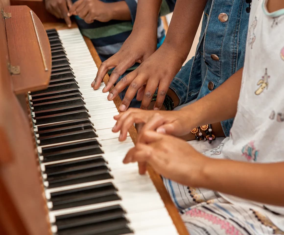 Kinderen spelen samen op de piano bij de BSO van kinderopvang Kind&co ludens