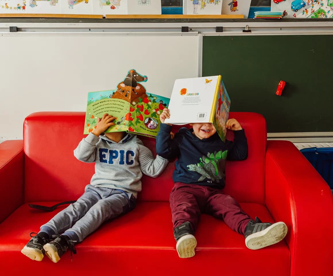 Kinderen spelen op de bank met boek bij Peuteropvang De Cirkel Utrecht van kinderopvang Kind&co ludens