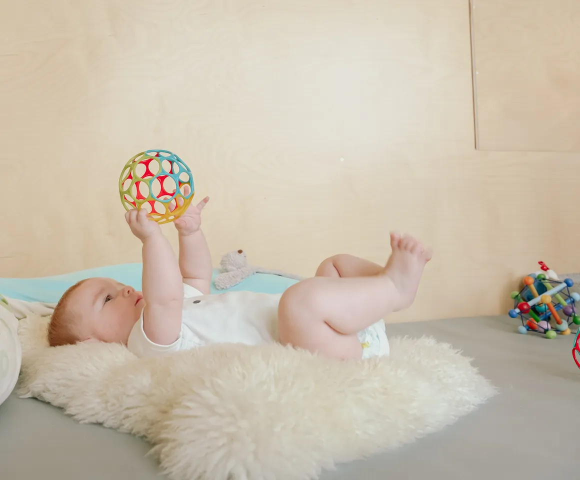 Baby speelt op een mat bij kinderopvang Kind&co ludens