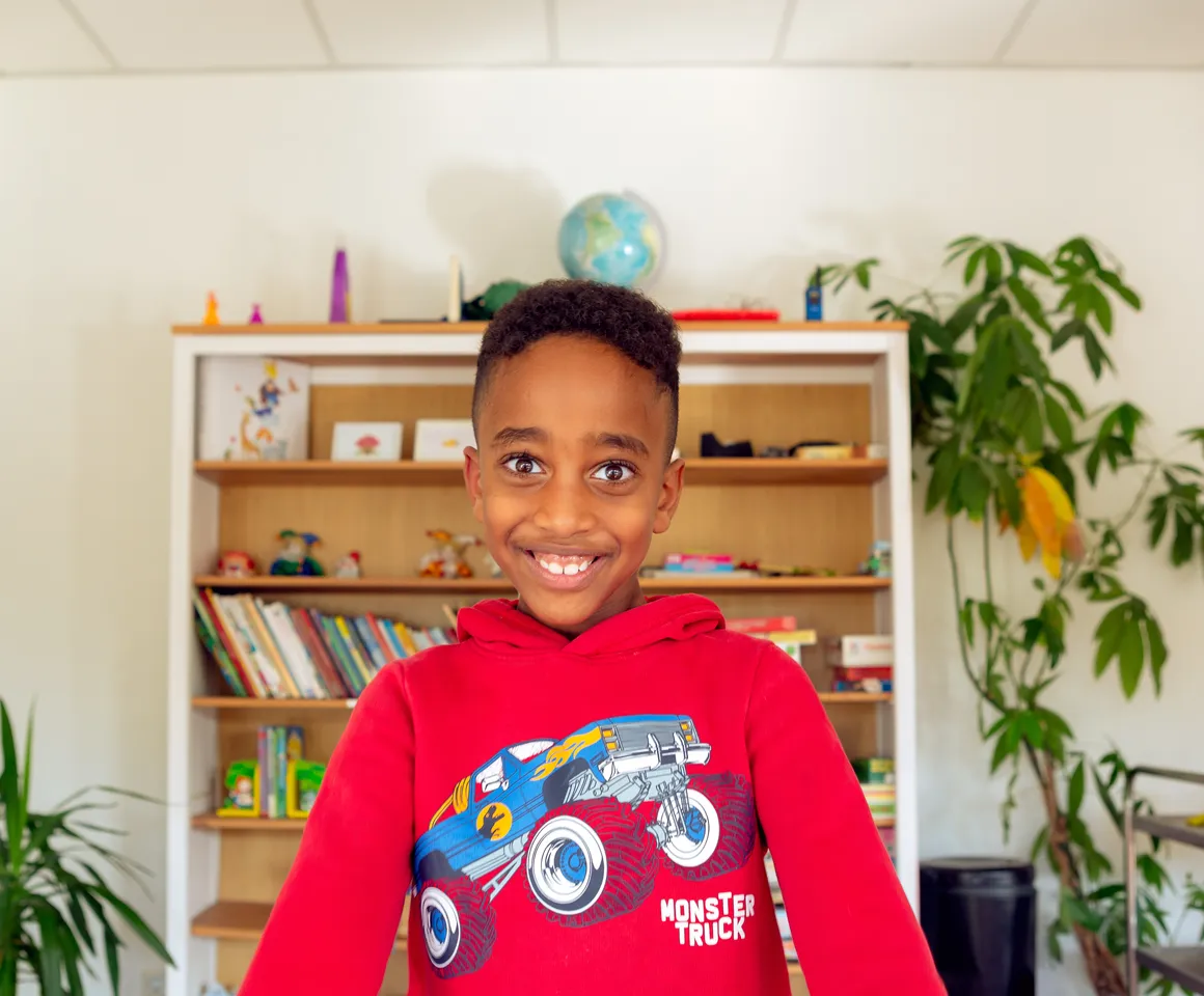 Kind bij de BSO lacht heel blij en straalt bij kinderopvang Kind&co ludens