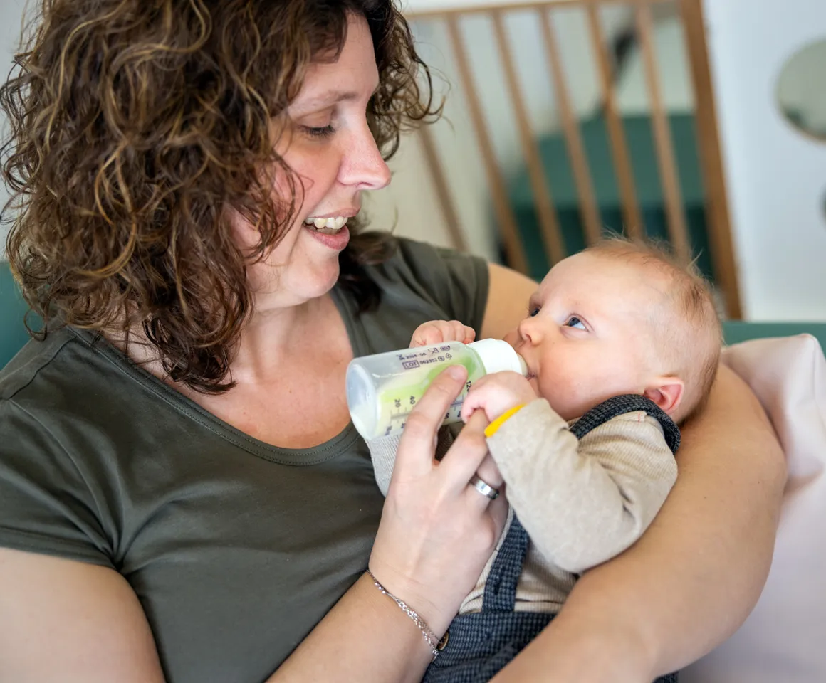 Baby krijgt een fles bij kinderopvang Kind&co ludens