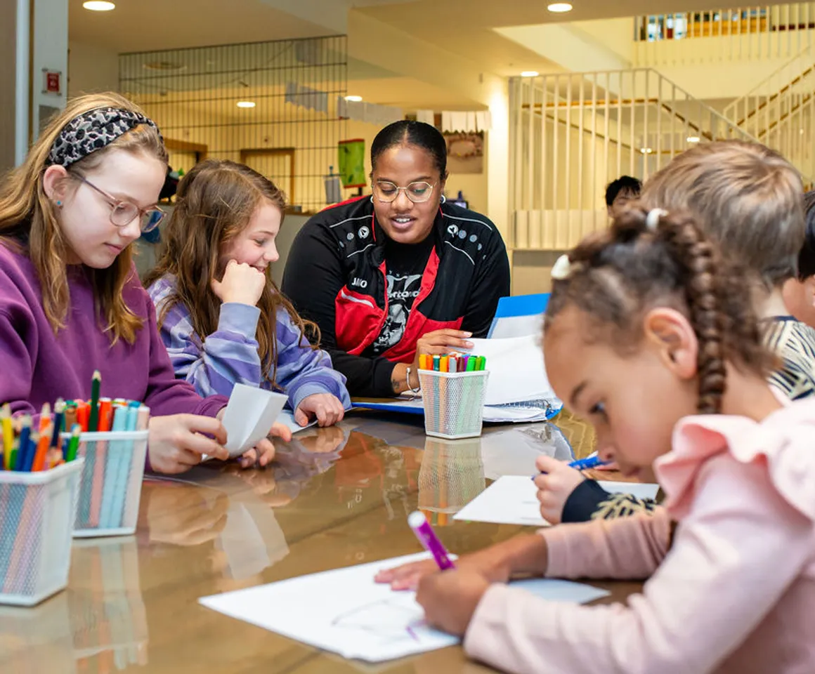 Kinderen zitten aan tafel en kleuren bij buitenschoolse opvang Grote beer, Kind&co ludens