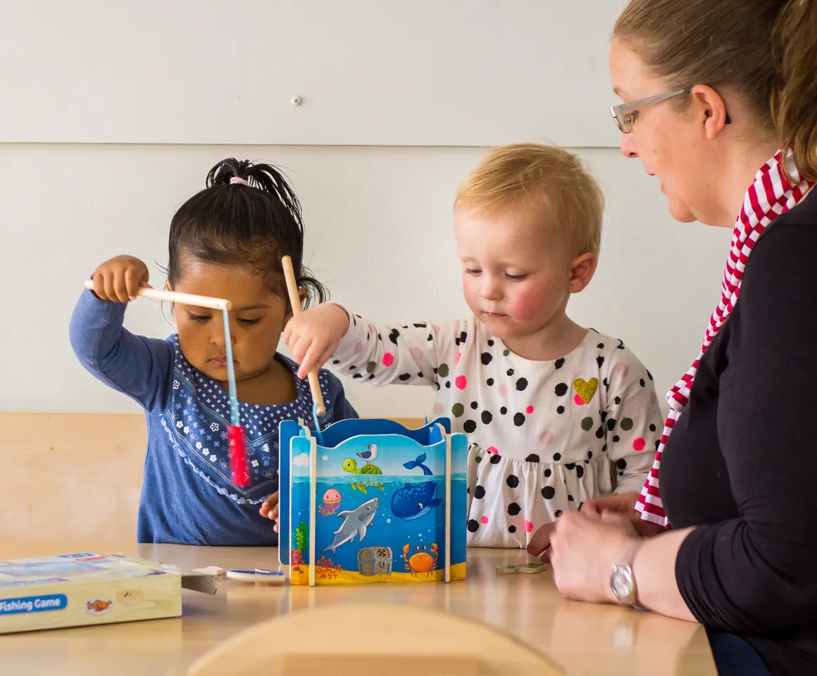 Kinderen spelen samen "Vissen" onder begeleiding van een pedagogisch medewerker bij kinderopvang Kind&co ludens