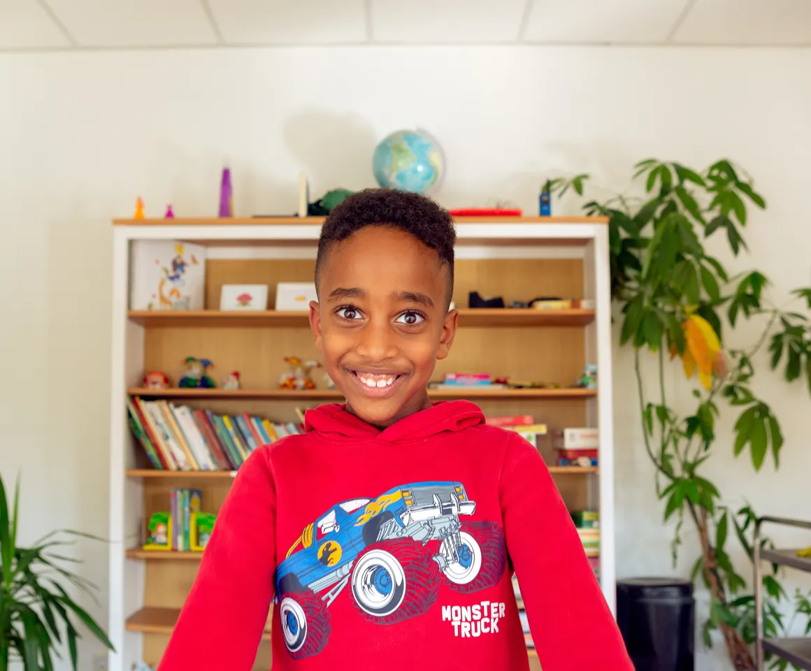 Kind bij de BSO lacht heel blij en straalt bij kinderopvang Kind&co ludens