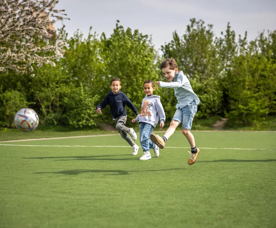Kinderen voetballen bij kinderopvang Kind&co ludens