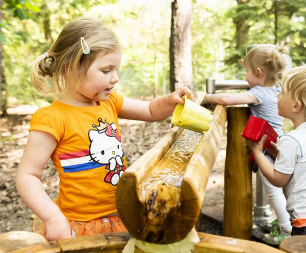 Kinderen spelen buiten met water bij Kinderdagverblijf Bilthoven De Bosuiltjes van kinderopvang Kind&co ludens