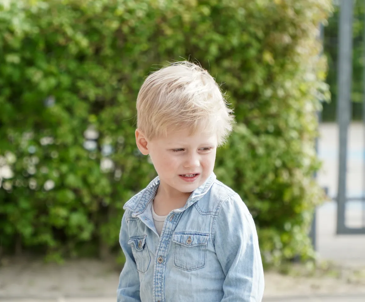 Kind staat buiten bij de heg bij gastouder van kinderopvang Kind&co ludens
