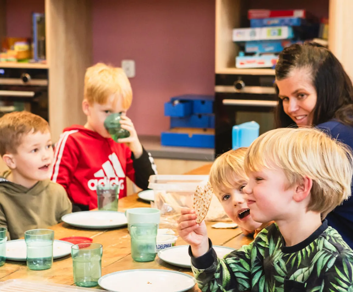 Kinderen eten een tussendoortje bij buitenschoolse opvang villa kakelbont van kinderopvang Kind&co Ludens