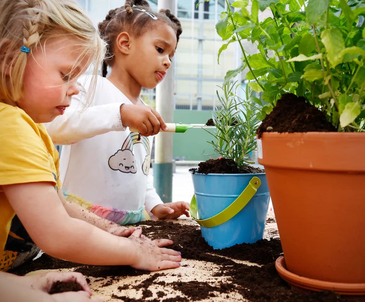 Kinderen van de peutergroep tuinieren in de moestuin bij kinderopvang Kind&co ludens