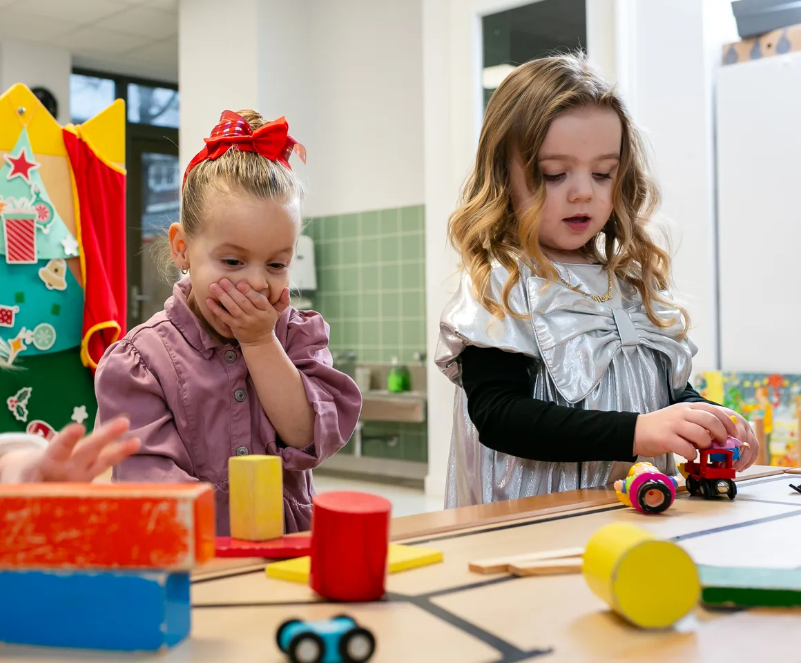 Kinderen van de peutergroep lachen en spelen samen bij kinderopvang Kind&co ludens