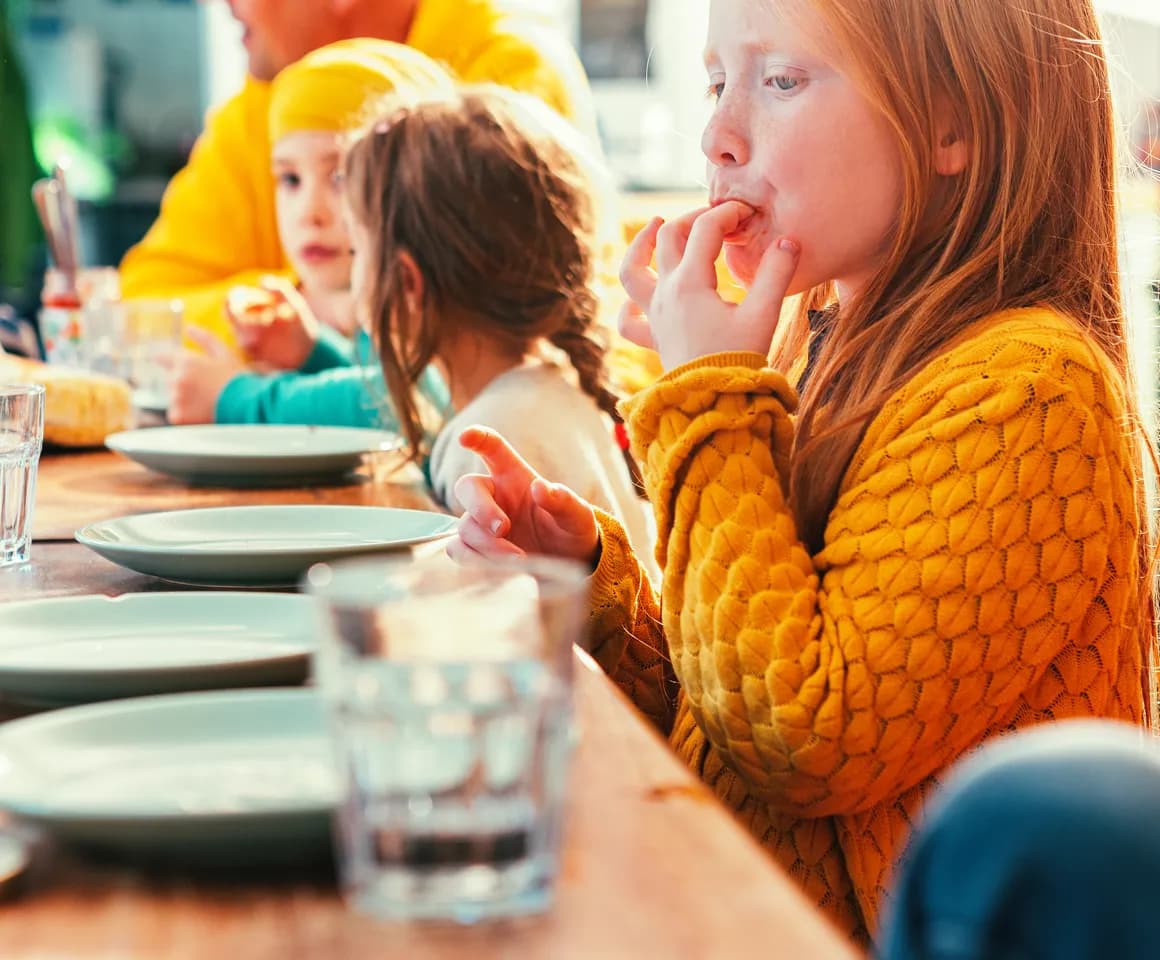 Kinderen eten samen aan tafel bij kinderopvang Kind&co ludens
