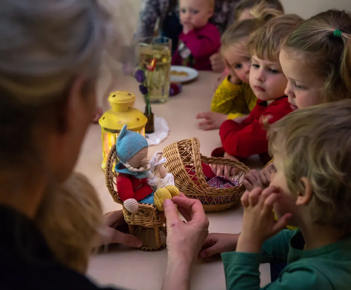 Kinderen luisteren naar een verhaal met echte popjes bij kinderdagverblijf Rozenrood, kinderopvang Kind&co ludens