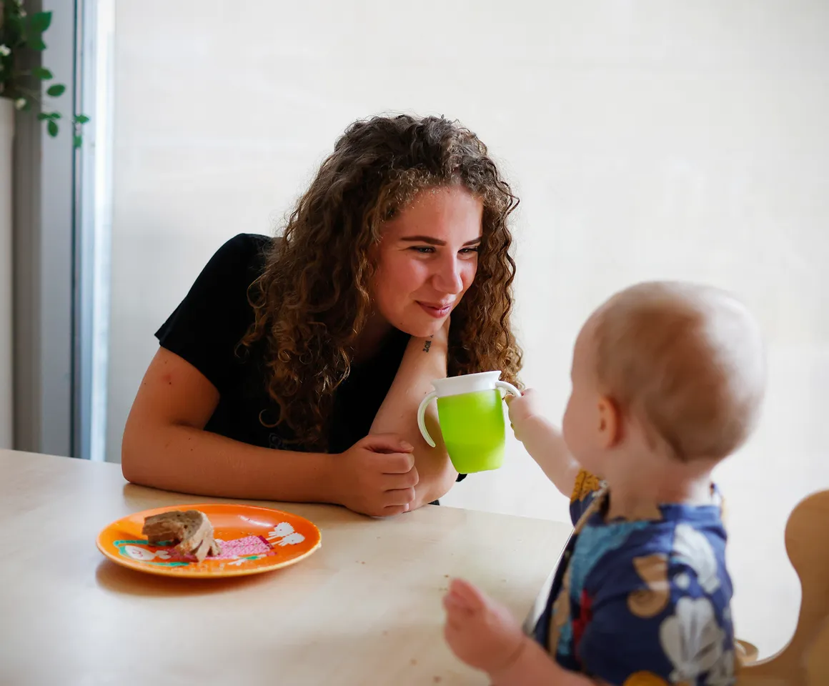Kind eet samen met pedagogisch medewerker bij kinderopvang Kind&co ludens