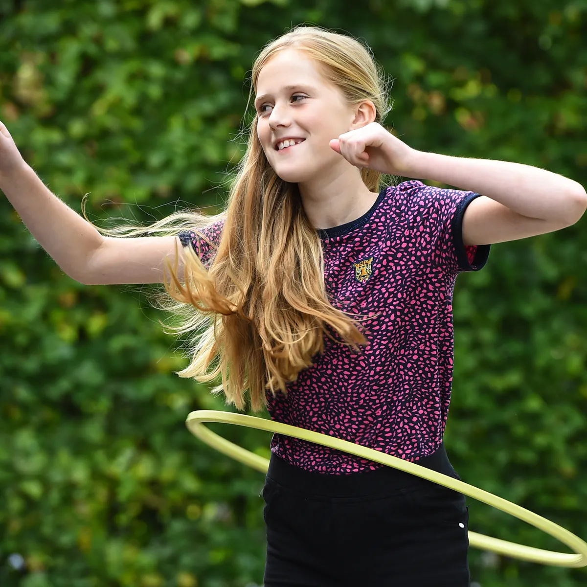 Kind van de BSO hoepelt buiten bij kinderopvang Kind&co ludens