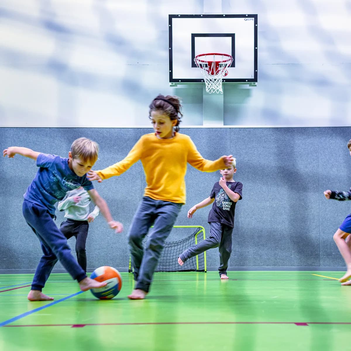Kinderen van de BSO spelen samen voetbal in de gymzaal bij kinderopvang Kind&co ludens