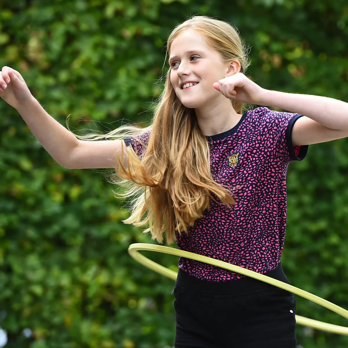 Kind van de BSO hoepelt buiten bij kinderopvang Kind&co ludens
