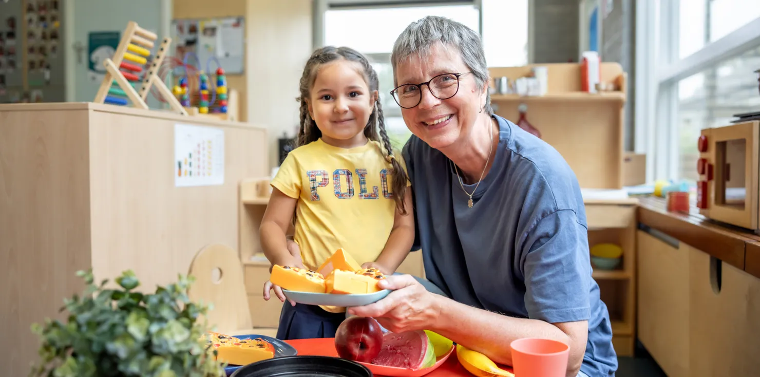 Kind speelt met pedagogisch medewerker in kinderkeuken bij kinderopvang Kind&co ludens