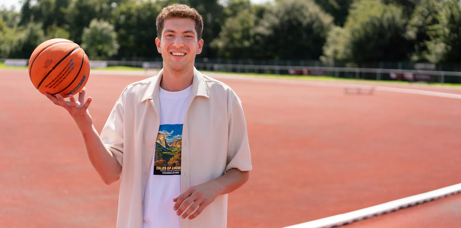 Collega met bal op een sportveld op de BSO