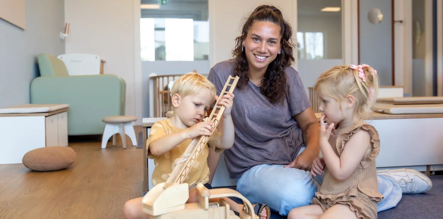 Kinderen spelen samen met pedagogisch medewerker bij kinderopvang Kind&co ludens