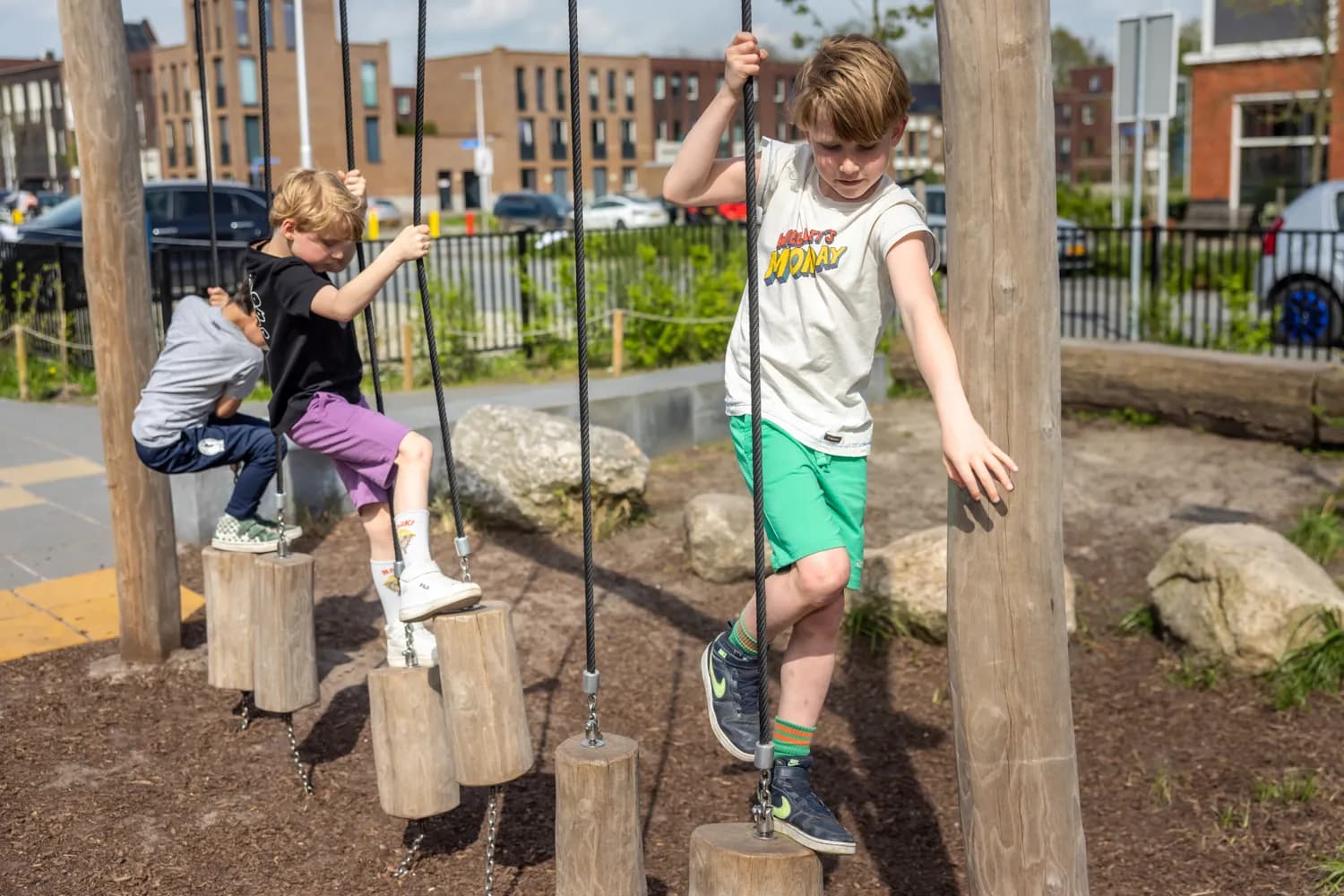 Kinderen spelen buiten op balansblokken bij kinderopvang Kind&co ludens