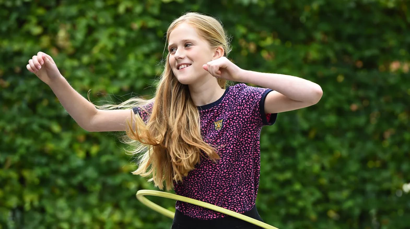 Kind van de BSO hoepelt buiten bij kinderopvang Kind&co ludens