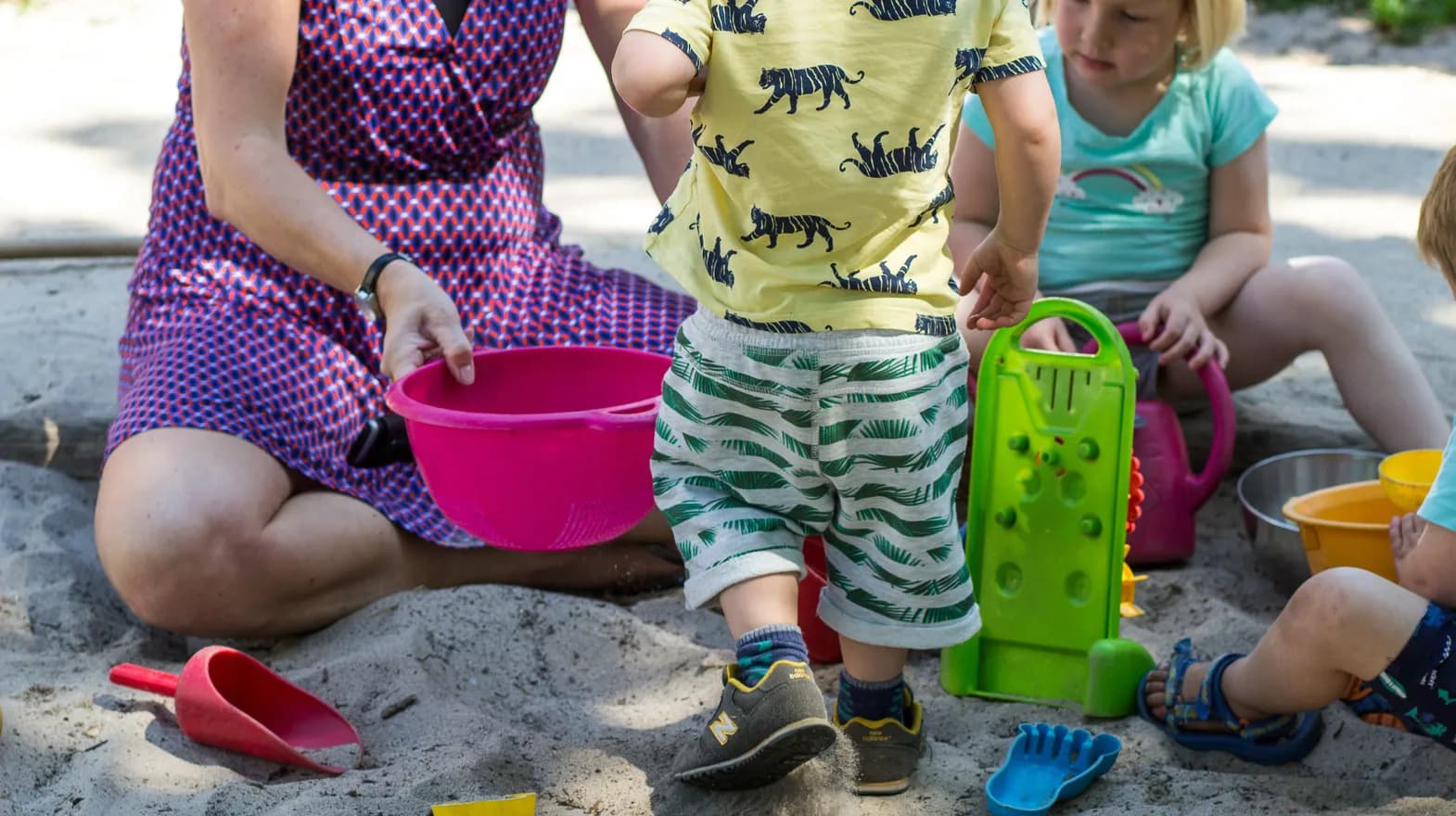 Kinderen spelen met pedagogisch medewerker in zandbak bij kinderdagverblijf Jodokus, kinderopvang Kind&co ludens