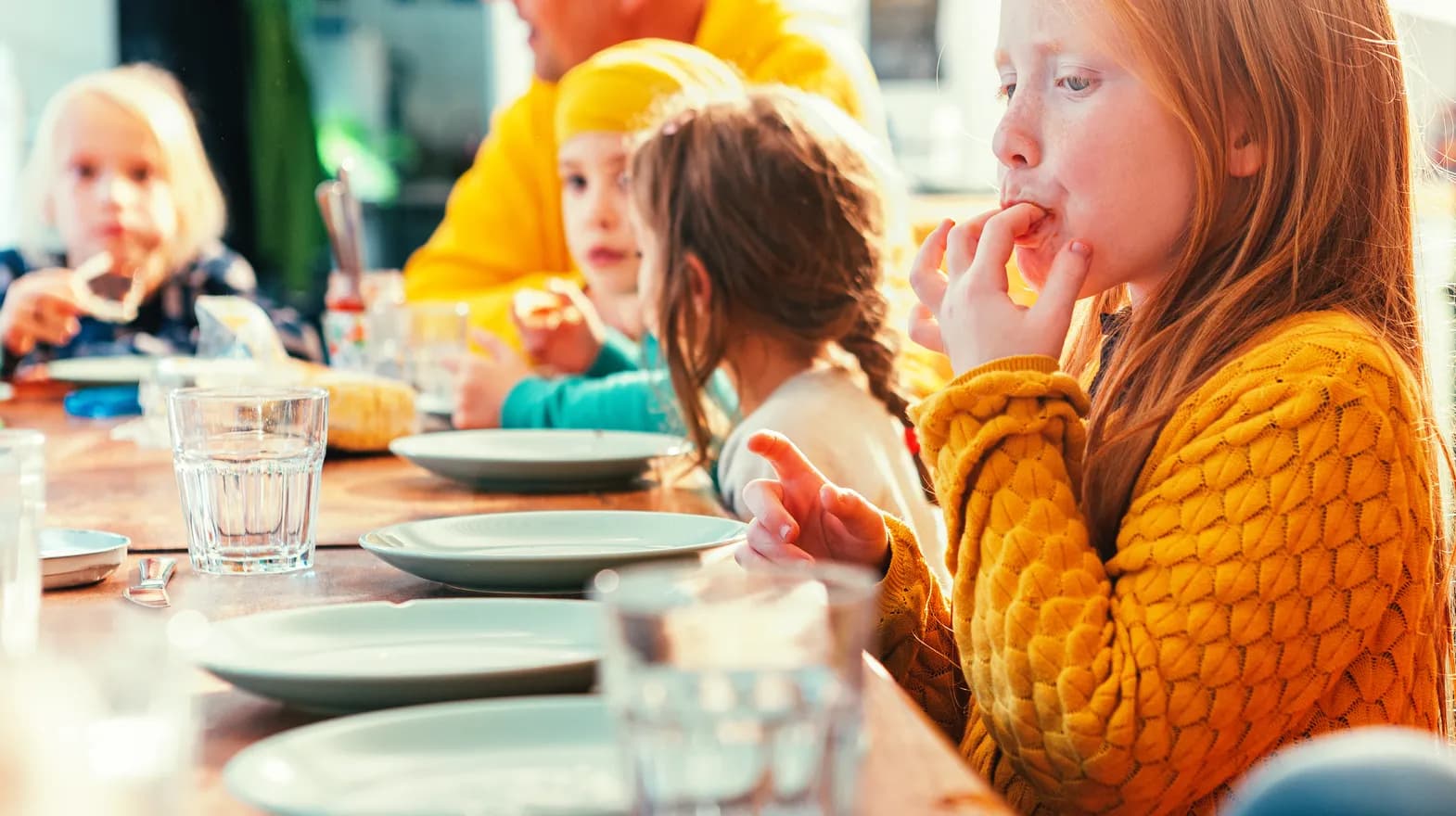 Kinderen eten samen aan tafel bij kinderopvang Kind&co ludens
