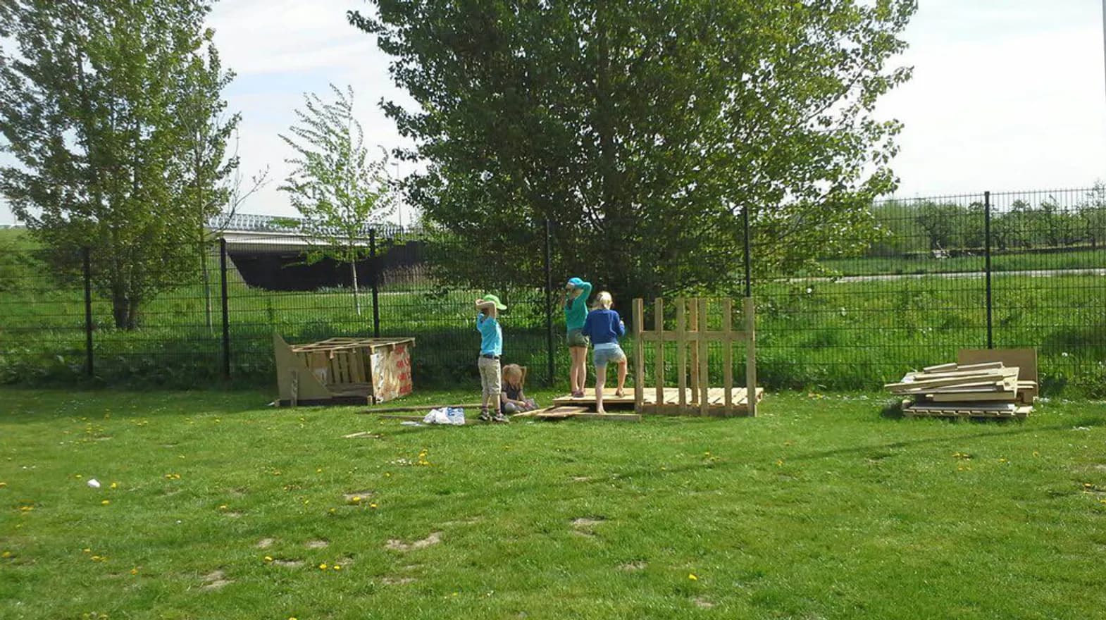 Kinderen maken een bouwwerk van houten pallets bij buitenschoolse opvang Gouddelvers, kinderopvang Kind&co ludens