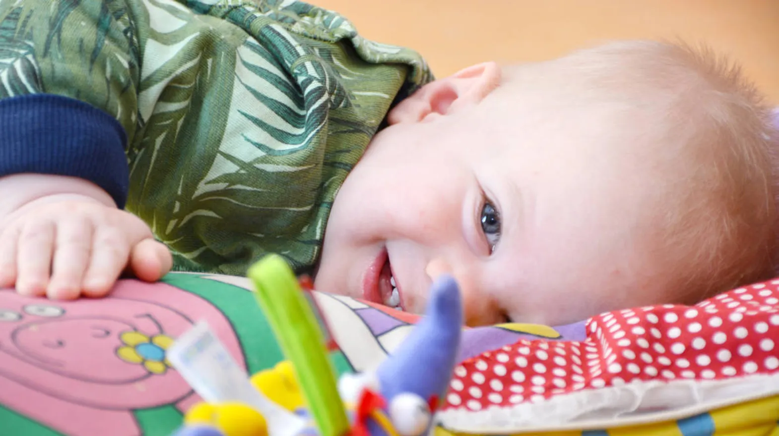 Kind ligt op speelkleed bij Kinderdagverblijf Weesp Speelrijk van kinderopvang Kind&co ludens