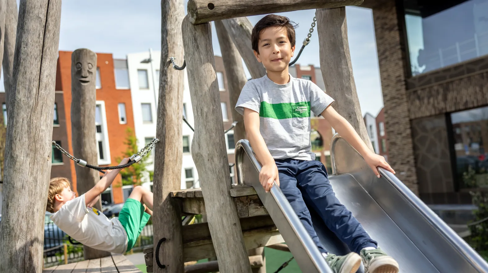 Kinderen spelen buiten met pedagogisch medewerker bij kinderopvang Kind&co ludens
