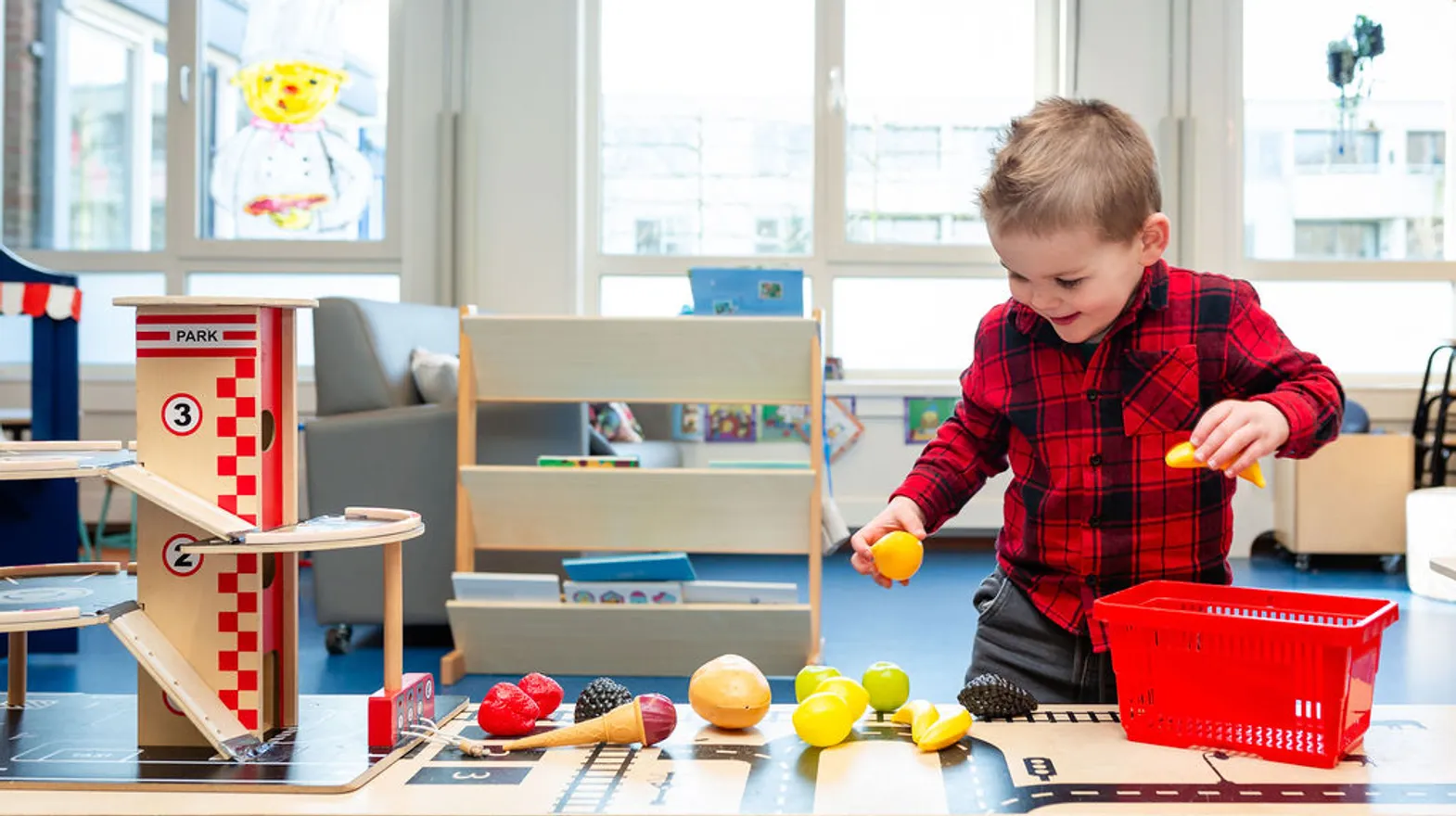 Kind speelt met speelgoedfruit bij Peuteropvang Uilen Kortenhoef van kinderopvang Kind&co ludens