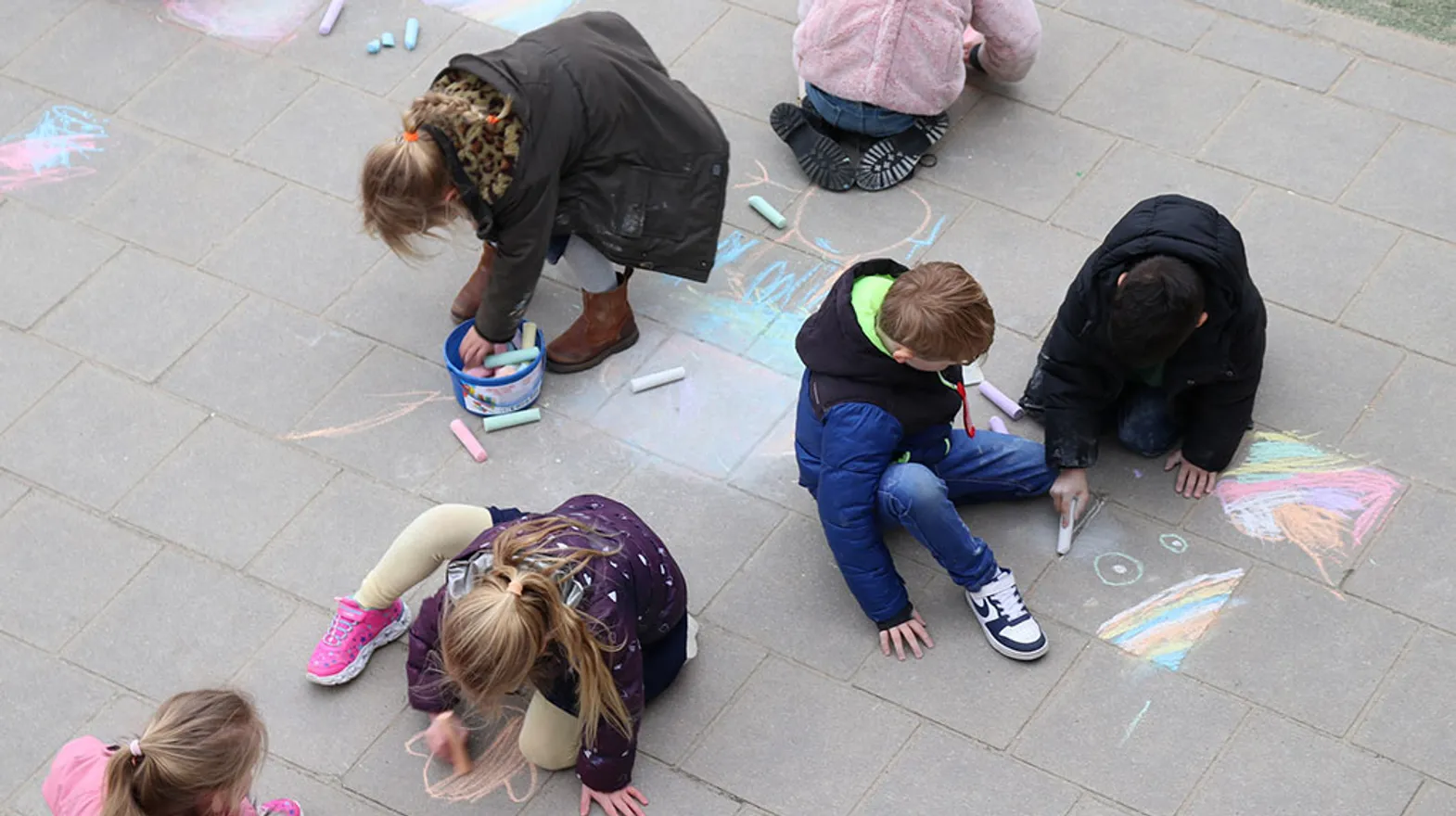 Kinderen buiten aan het krijten bij BSO-Kersenbende van kinderopvang Kind&co ludens