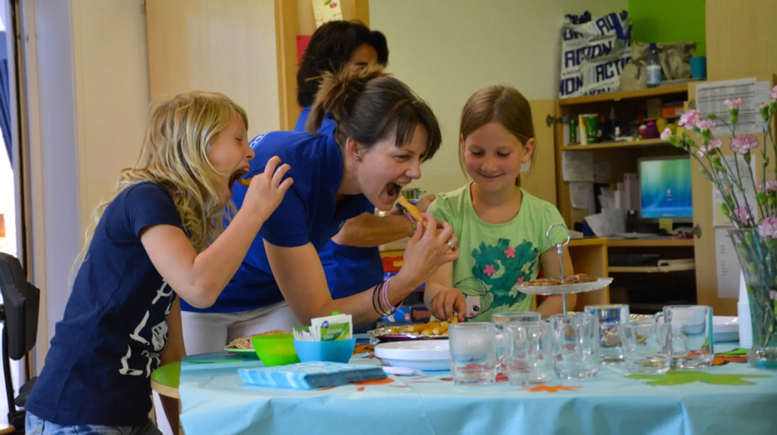 Kinderen eten lachend een kaastengel bij buitenschoolse opvang spelerij, kinderopvang Kind&co Ludens