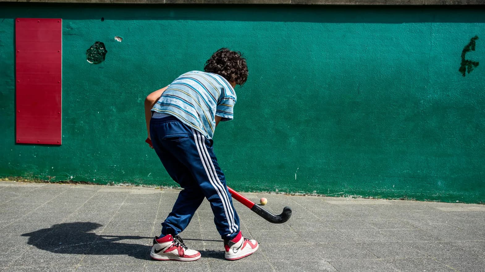 Kind is buiten aan het hockeyen bij buitenschoolse opvang Maanvis, kinderopvang Kind&co Ludens