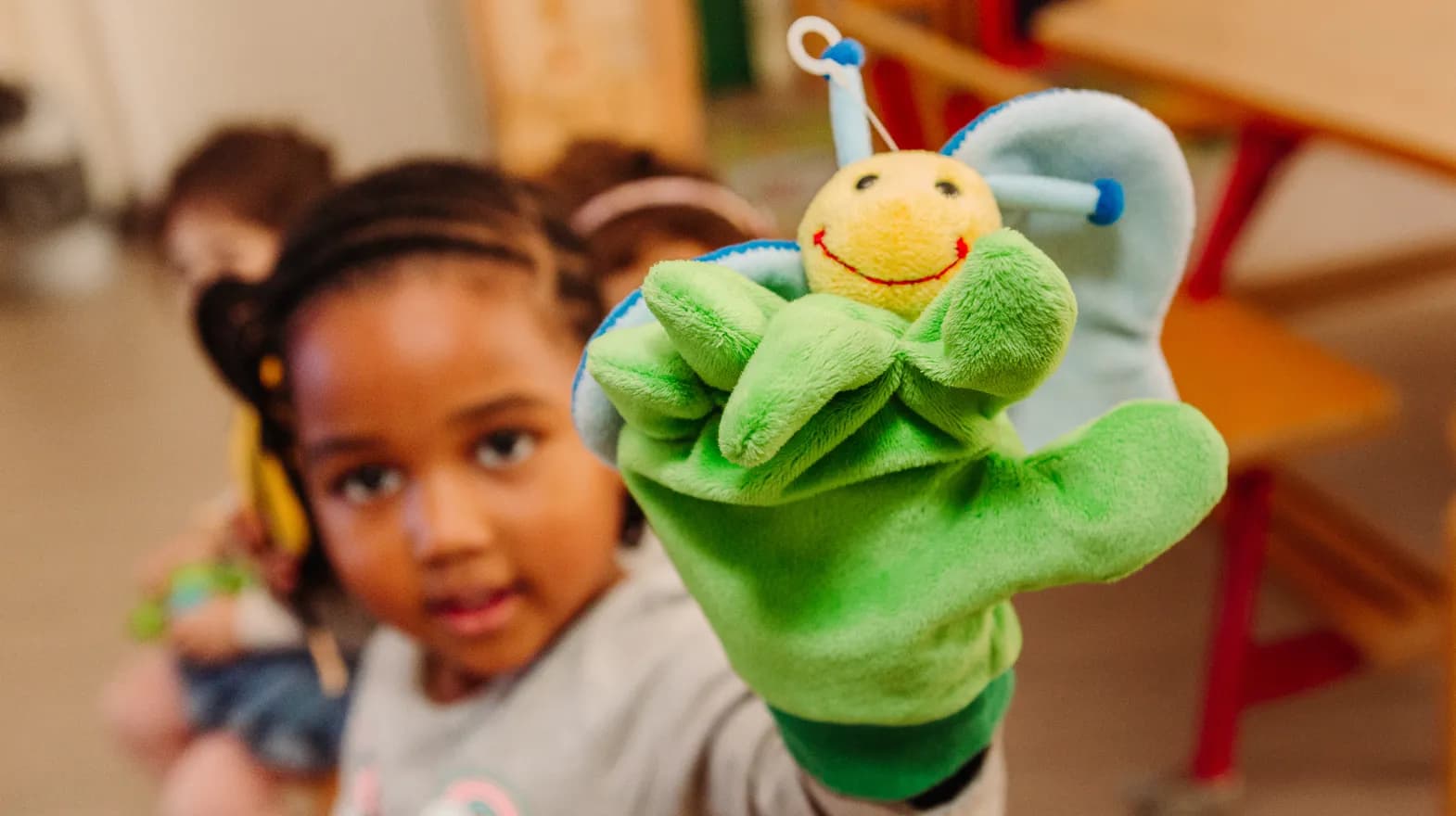 Kind van de peutergroep speelt met handpop bij kinderopvang Kind&co ludens