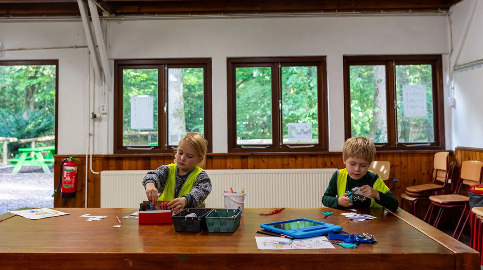 Kinderen aan tafel aan het knutselen bij BSO Scouts Baarn van kinderopvang Kind&co ludens